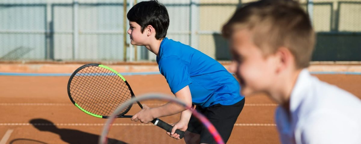 criancas-de-lado-jogando-tenis-de-duplas