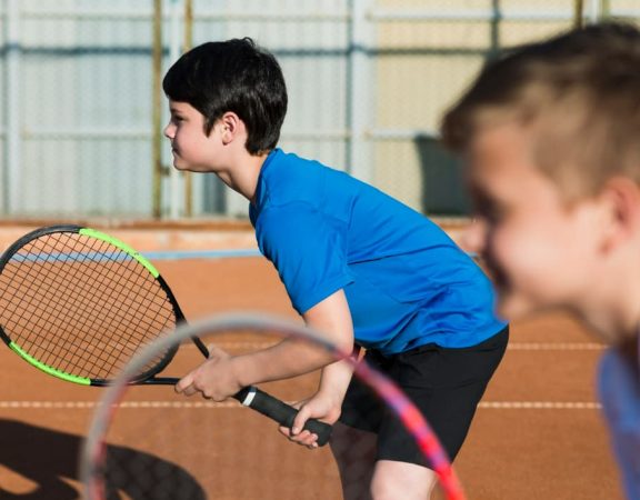 criancas-de-lado-jogando-tenis-de-duplas
