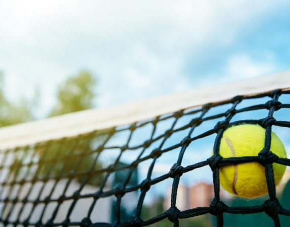 bola de tenis e beach tennis batendo na rede